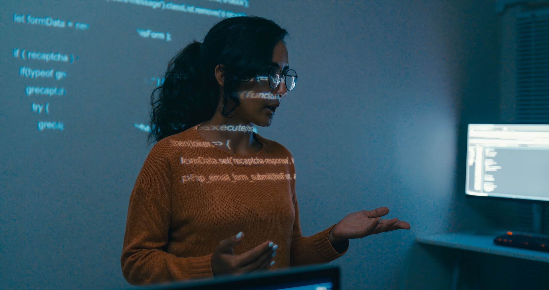 Closeup female programmer is giving interactive training session, focusing on hands-on learning in digital classroom environment. Software developer, artificial intelligence and programming.